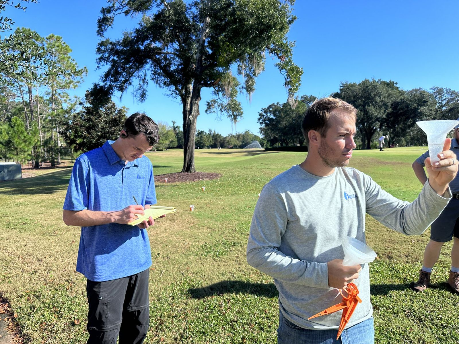 Insight staff running a catch-can uniformity test on turf
