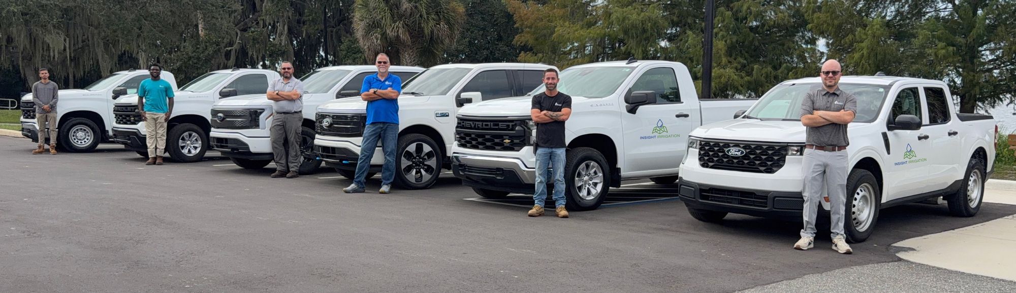 Insight Irrigation field, monitoring and IT staff standing in front of six company service trucks